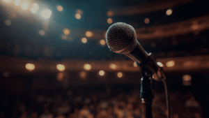 Microphone on an empty stage in front of a live audience representing the financial risks covered by non-appearance insurance.